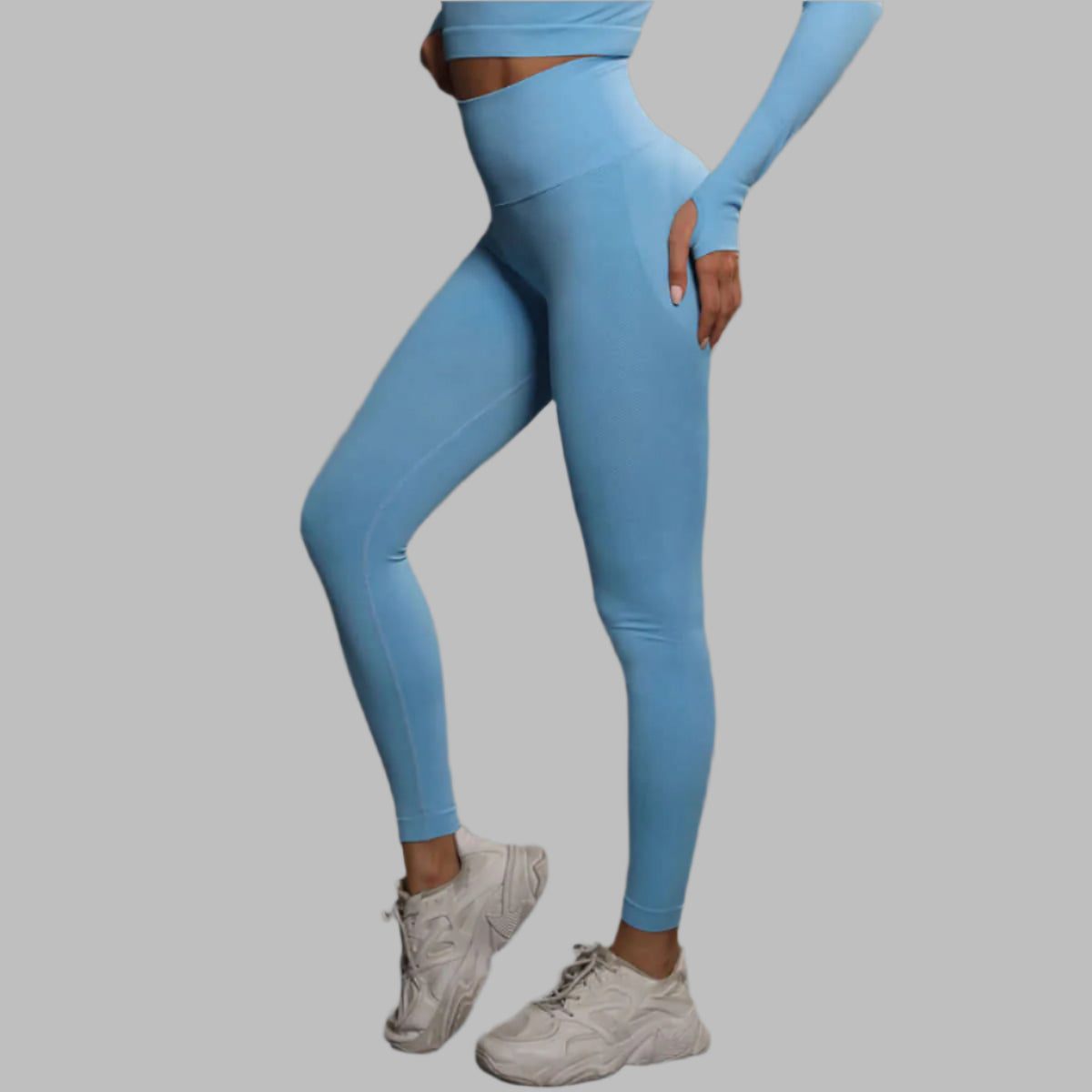 Woman wearing high waist blue leggings and matching top, showing the athletic fit and comfortable design, ideal for workouts.