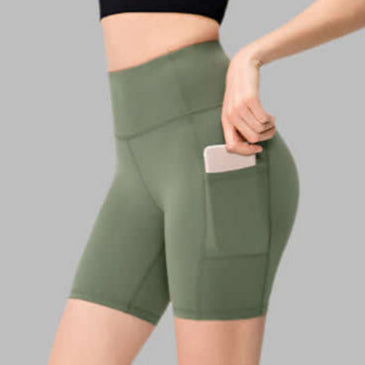 Woman wearing green pocket sport shorts with a phone in the side pocket.
