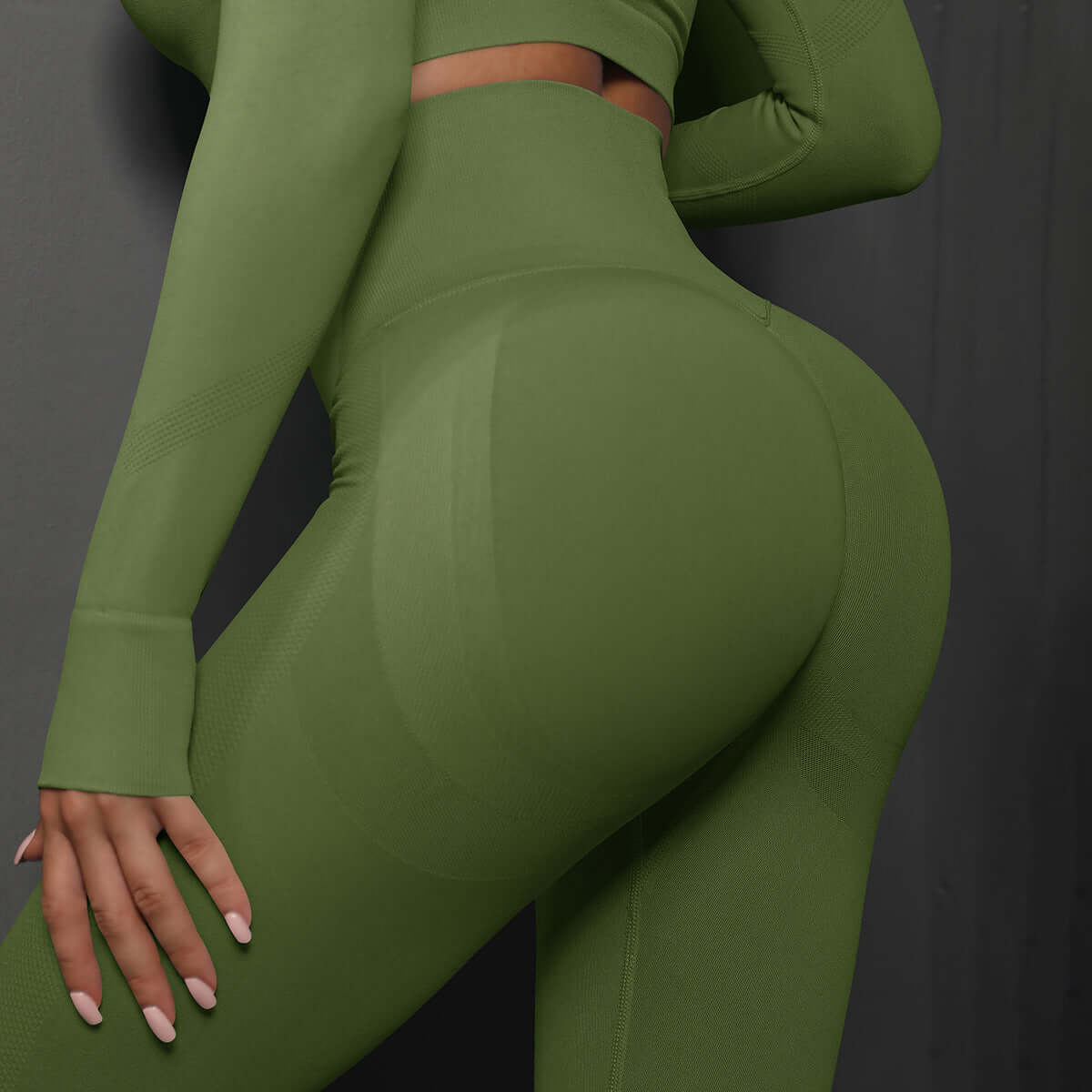 Back view of woman wearing olive green high waist leggings, showcasing seamless fit and comfort with matching long-sleeve top.