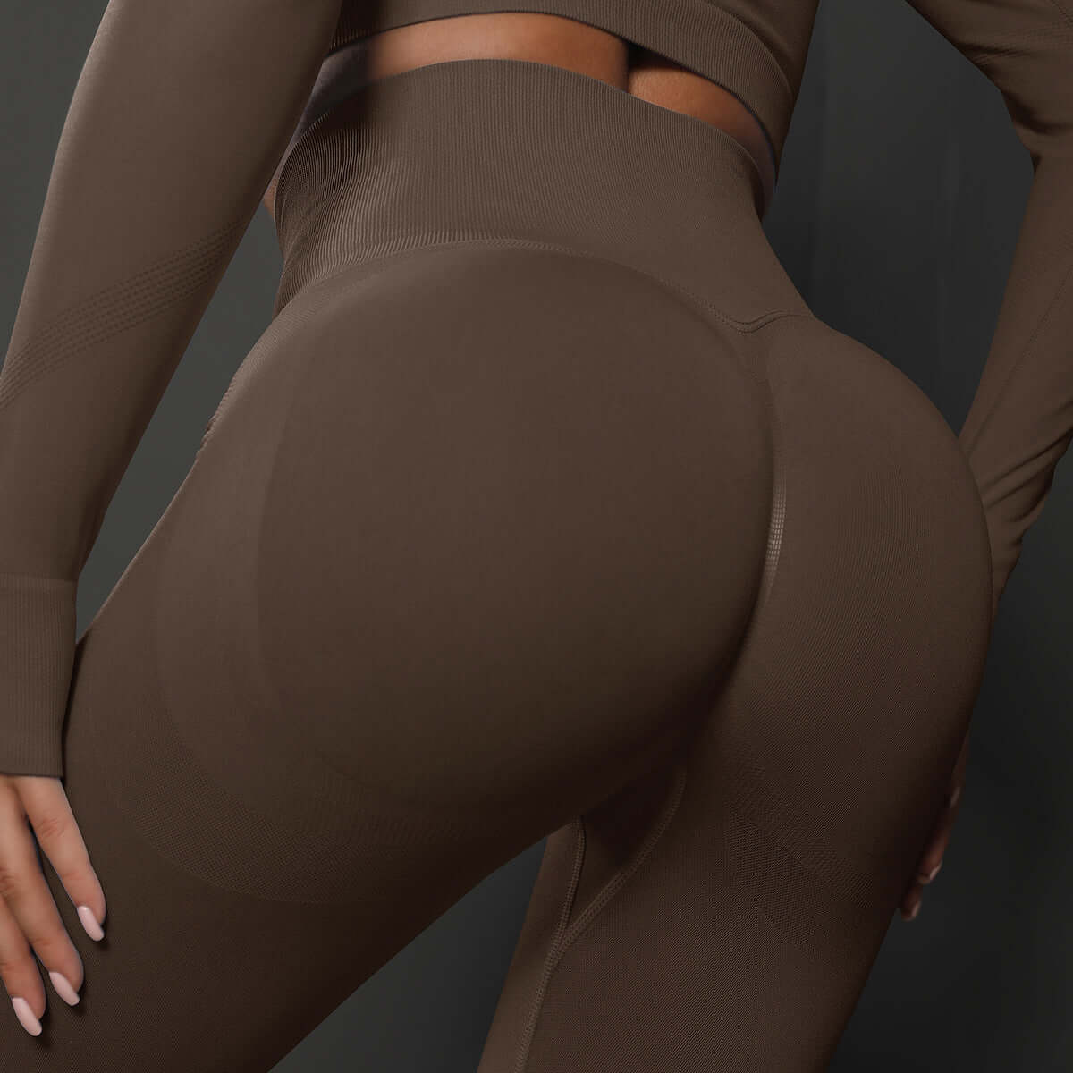 Close-up view of a model wearing brown high waist leggings showcasing seamless design and fit.
