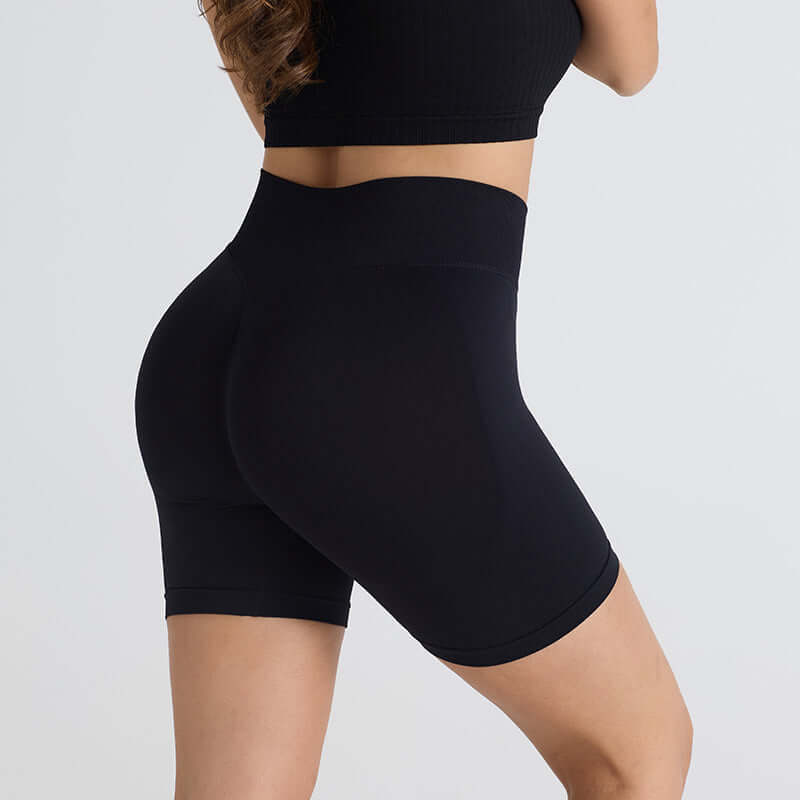 Woman wearing black booty-lifting sports shorts with high waistband for enhanced fit and curve sculpting.
