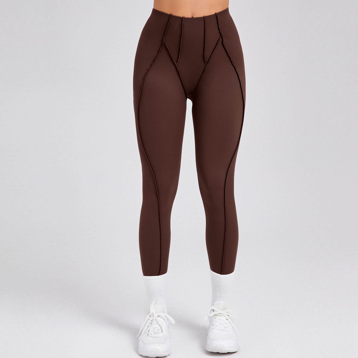 Person wearing brown compression gym leggings with white sneakers
