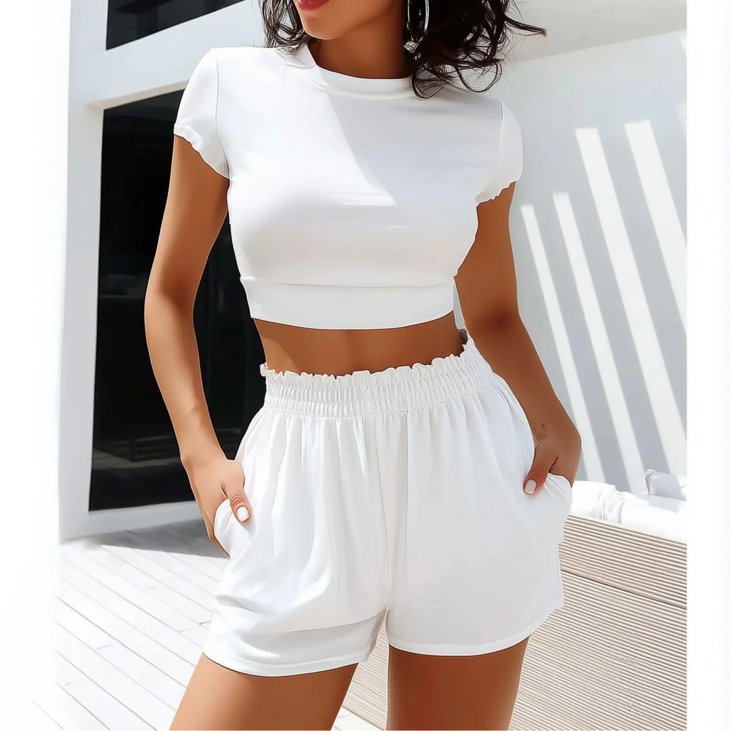 Woman wearing white casual sports suit, featuring a cropped tee and elastic waist shorts, perfect for lounging or light workouts.