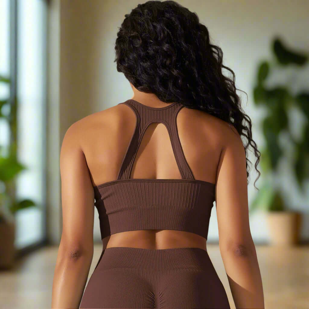 Back view of a woman wearing a brown seamless bra and shorts, ideal for yoga or fitness, highlighting breathable, quick-drying fabric.