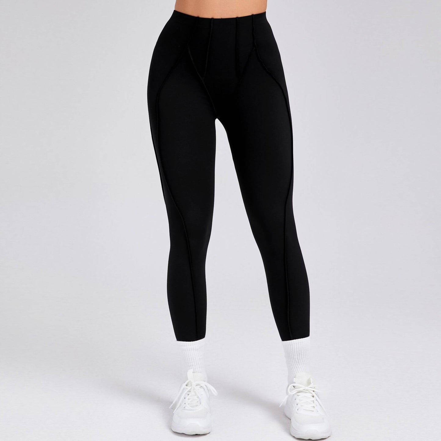 High-waisted black compression gym leggings for women, designed for fitness and comfort, paired with white sneakers.