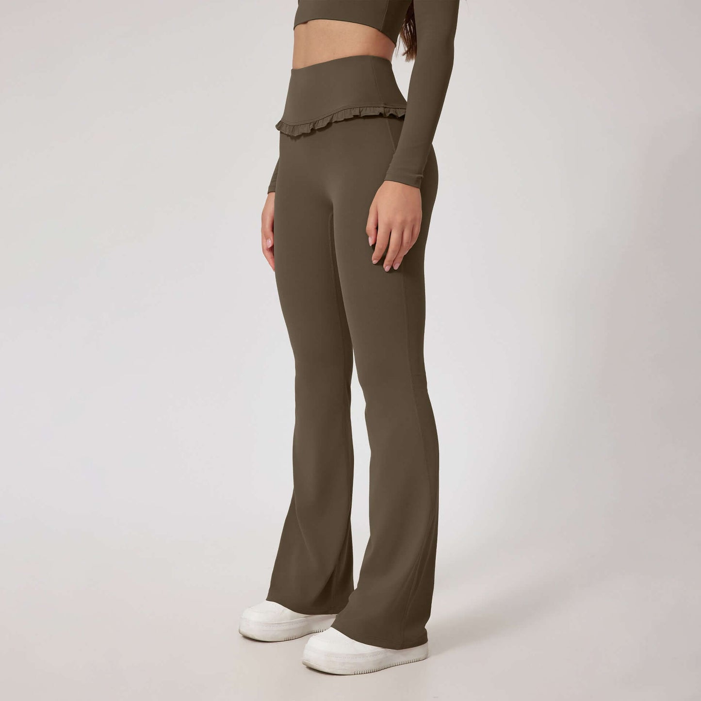 Woman wearing olive high waist leggings with flared legs and ruffle detail