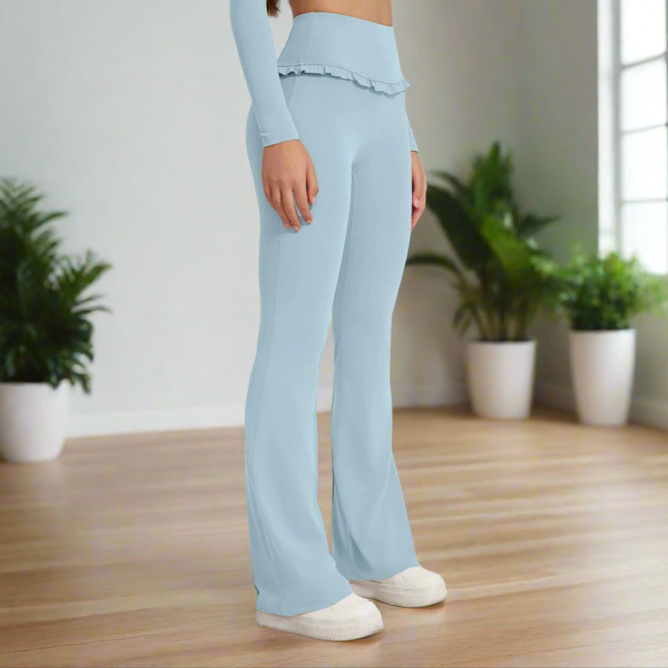 Woman wearing high waist blue leggings and matching top with white sneakers.