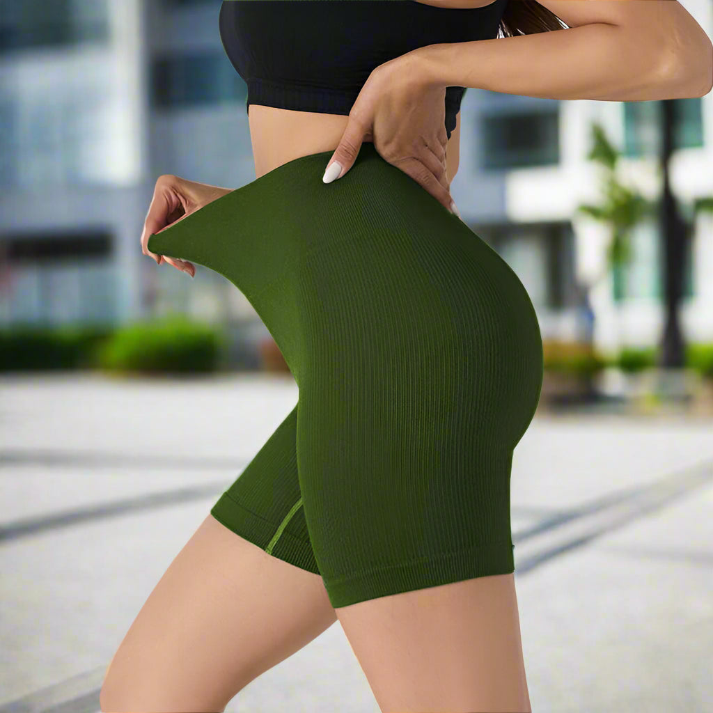 Woman wearing seamless stretch shorts in dark green, showcasing flexibility and flattering fit, ideal for yoga or casual wear.