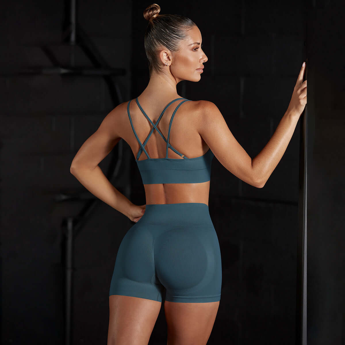 Woman wearing a seamless stretch sports vest and shorts, featuring a breathable cotton blend, ideal for yoga and training.