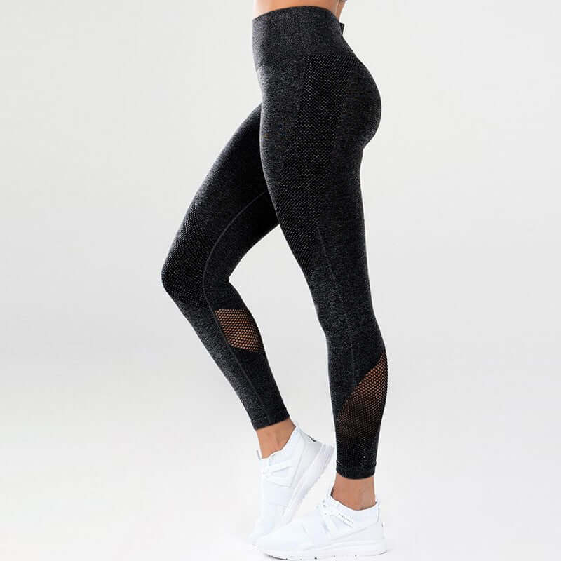 High-waisted black fitness leggings with mesh panels for workouts, featuring a snug fit and comfortable material.