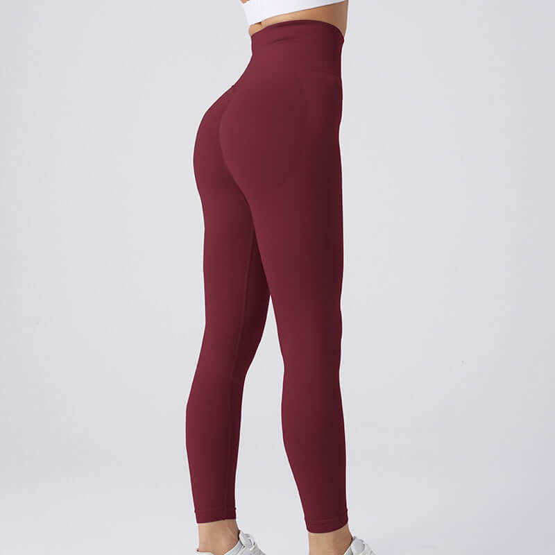 Woman wearing maroon workout running leggings, showcasing rear view. Available in sizes S-L for 40-65 kg. Perfect for fitness and comfort.