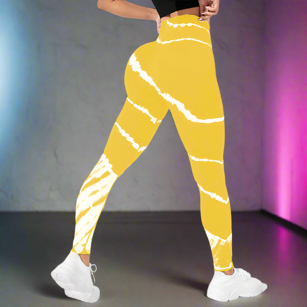 Bright yellow tie-dye compression workout pants on model, showcasing high-waist and snug fit. Ideal for exercise and active wear.