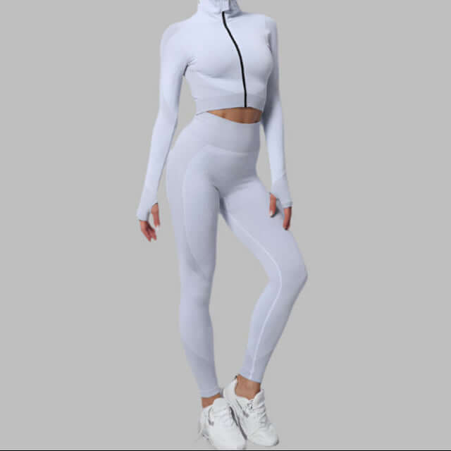 White athletic sport set featuring high-waisted leggings and a long-sleeve crop top with zipper, perfect for workouts and fitness.