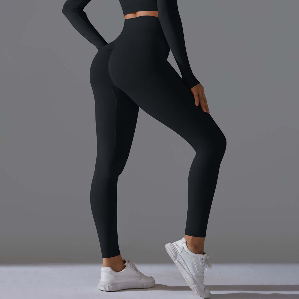 Woman wearing black seamless high waist leggings with white sneakers, showcasing a stylish and comfortable athletic outfit.