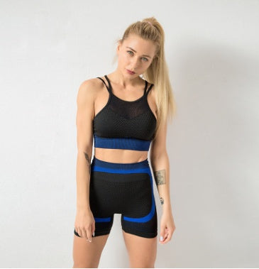 Woman wearing a stylish two-piece gym set, black with blue accents, ideal for fitness or workout sessions.