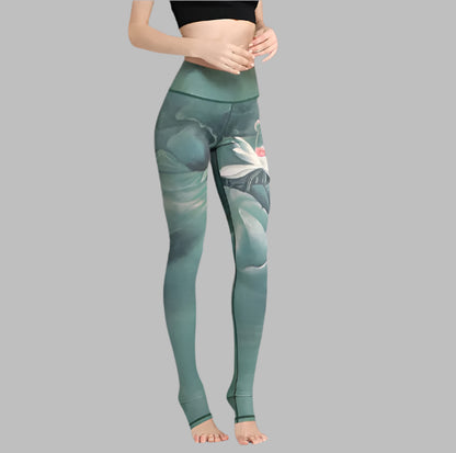 Woman wearing high-waisted printed yoga pants with floral design on grey backdrop.