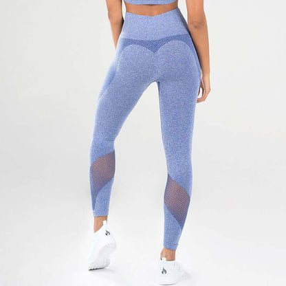 Woman wearing blue fitness leggings with mesh panels, showcasing athletic design and snug fit, standing in studio setting.