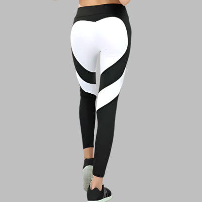 Woman wearing Heart Stitch Yoga leggings with black and white heart design, viewed from the back. Ideal for fitness and yoga enthusiasts.