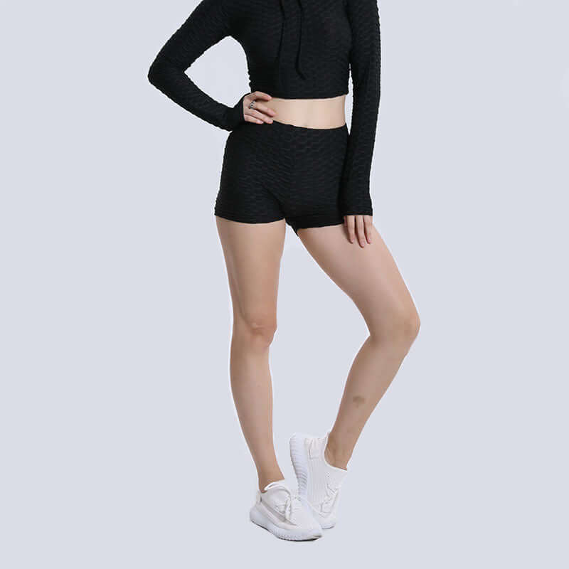 Model wearing high waist shorts and matching top with white sneakers