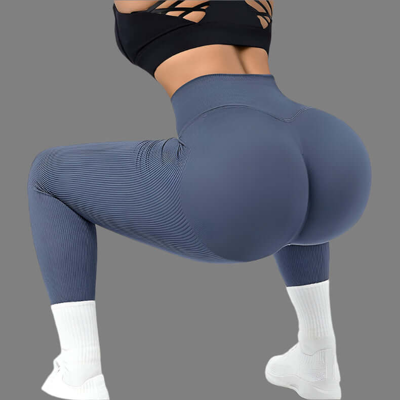 Woman wearing seamless fitness leggings in blue, showcasing flexibility and stretchability, squat pose emphasized for exercise comfort.