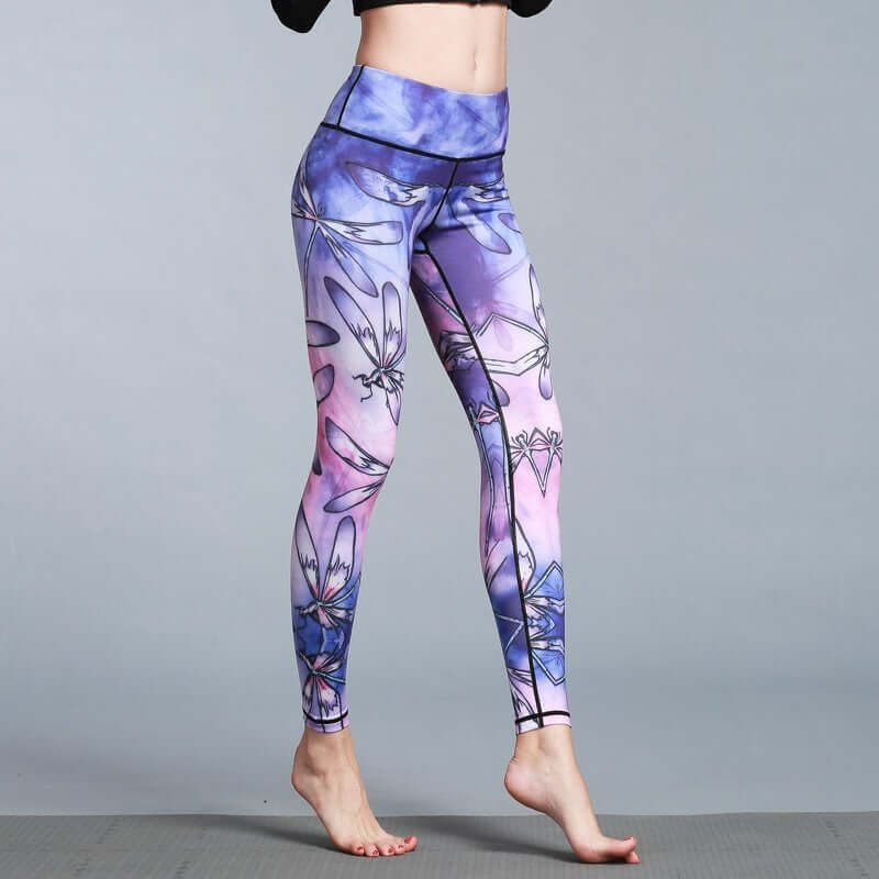 Woman wearing vibrant printed yoga leggings in shades of purple and pink, designed for flexibility and style.