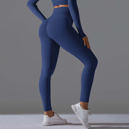 Woman in seamless high waist blue leggings with white sneakers against a gray background, showcasing back and side profiles.