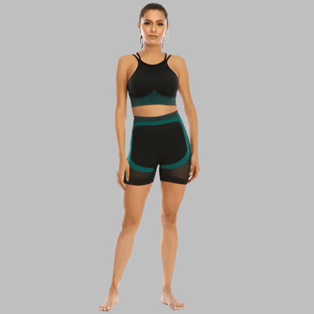 Woman wearing a black and teal 2PCS gym set with sports bra and shorts, standing against a gray background, showcasing activewear fashion.