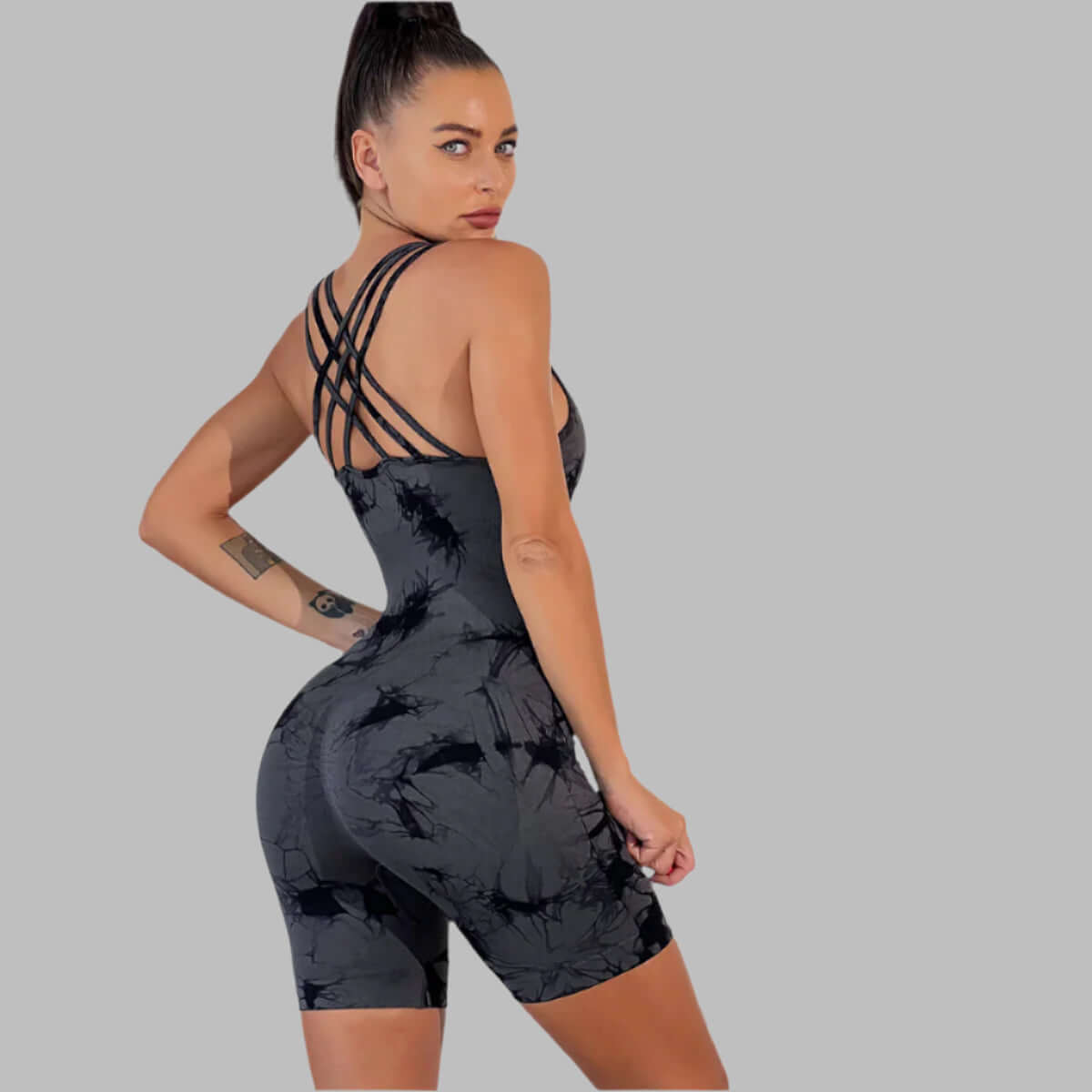 Black tie-dye strappy romper in organic cotton. Features relaxed fit and breathable material for comfort.