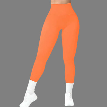 Bright orange seamless fitness leggings on a gray background, showcasing high-waisted design, perfect for workout and athleisure style.