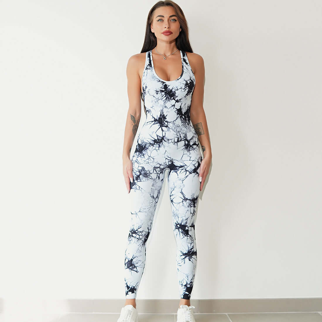 Woman wearing a stylish black and white print workout jumpsuit, ideal for fitness and activewear activities.