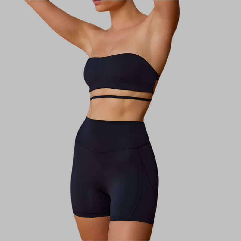 Woman wearing a sleek black workout beauty set with strapless top and matching shorts.