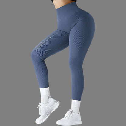 Woman wearing seamless fitness leggings, high-waisted design, paired with white sneakers, showcasing stretch and comfort.