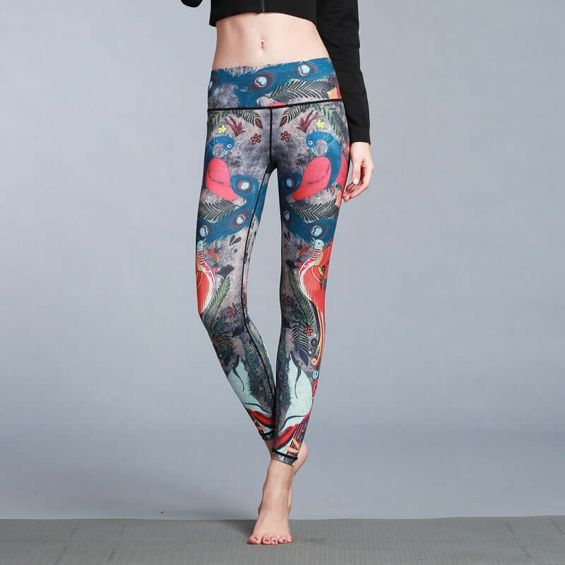 Woman wearing vibrant printed yoga leggings with abstract patterns and barefoot on a studio floor.