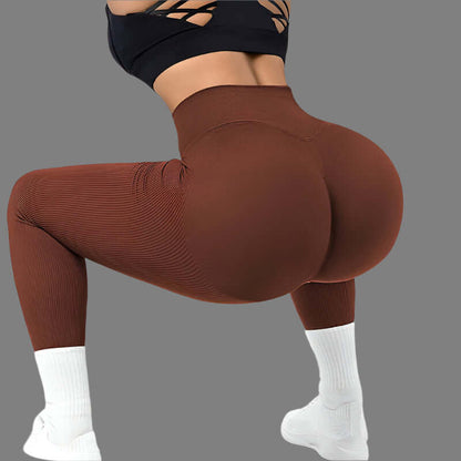 Woman wearing high waist seamless leggings and sports bra in yoga pose, showcasing flexible fit and stretch in brown color for fitness.