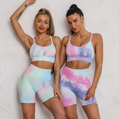 Two women wearing pastel tie-dye seamless sport sets, featuring matching sports bras and shorts, perfect for workout or leisure.