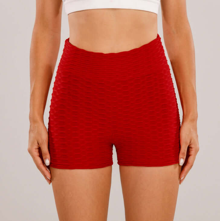 Red high waist shorts, textured design, ideal for workouts or casual wear, shown on model for fit and style illustration.