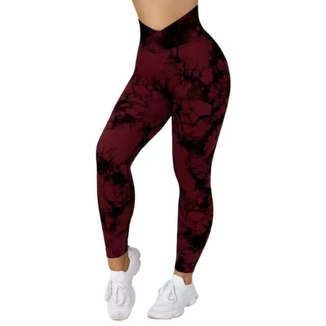 Woman wearing burgundy tie-dye leggings and white shoes, displaying stylish workout fashion.