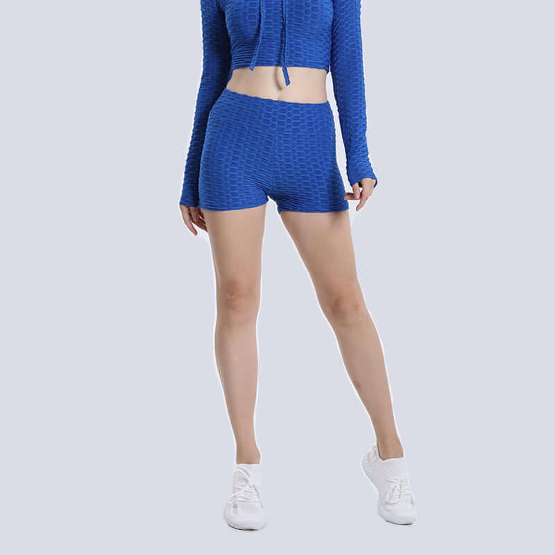 Woman wearing high waist blue textured shorts with a matching top, showcasing front view against a light gray background.