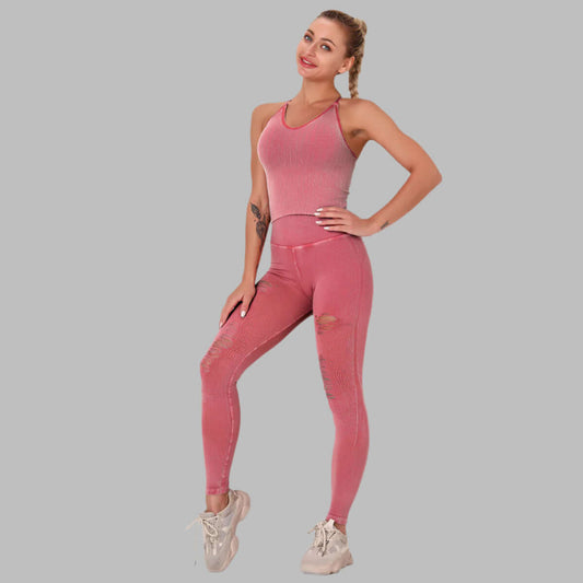 Woman in pink seamless exercise suit standing confidently with hands on hips, showcasing comfortable activewear style on a gray background.