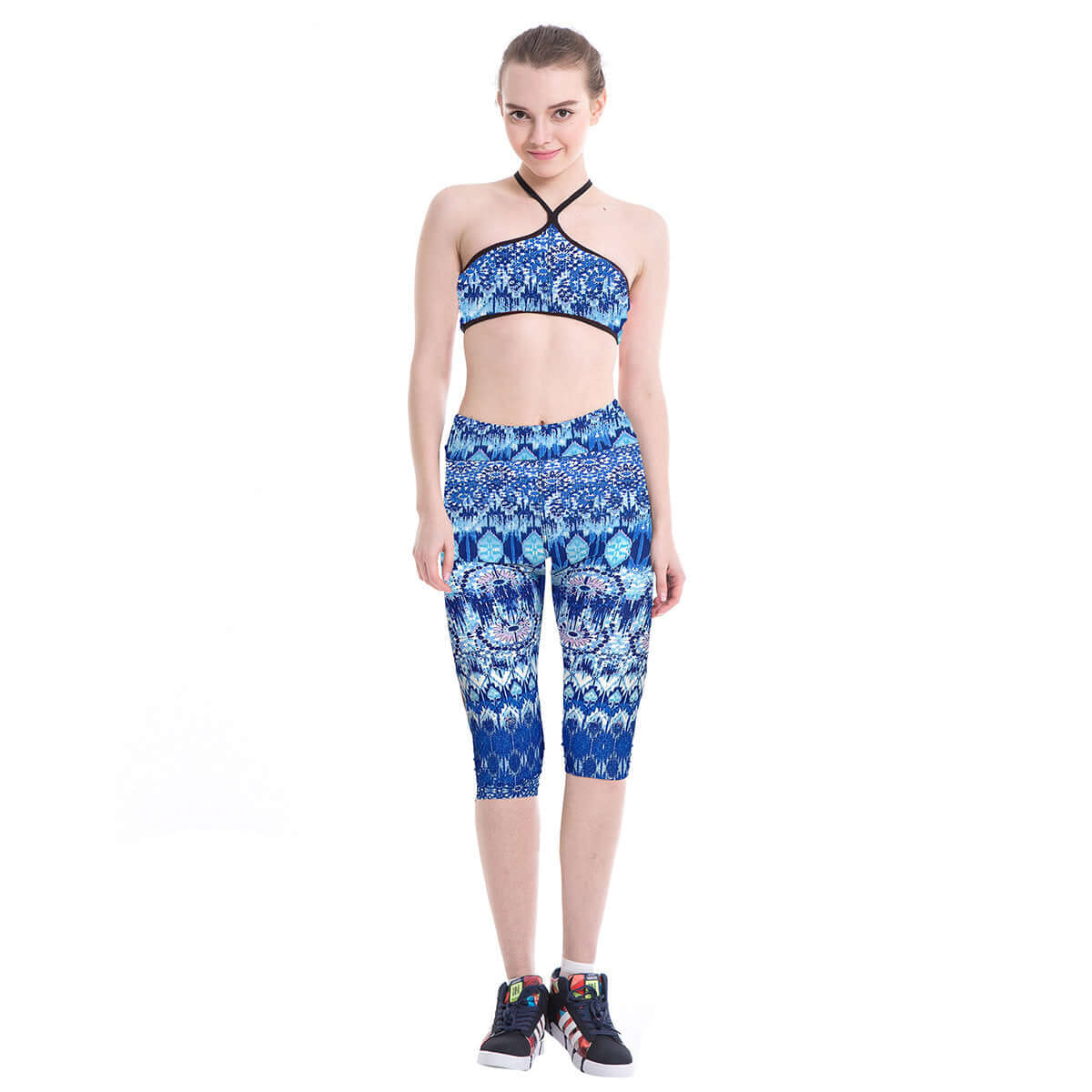 Woman wearing blue printed yoga leggings and top, showcasing athletic style and comfort for fitness and yoga activities.