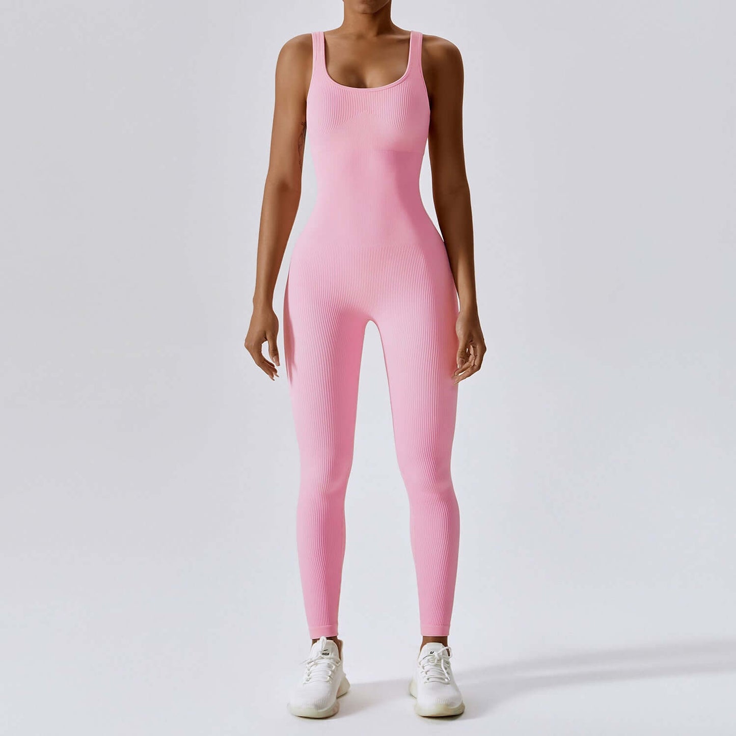 Light pink sculpting yoga bodysuit, sleeveless and scoop-neck, designed for comfort and style in active or casual wear. Seamless and moisture-wicking.