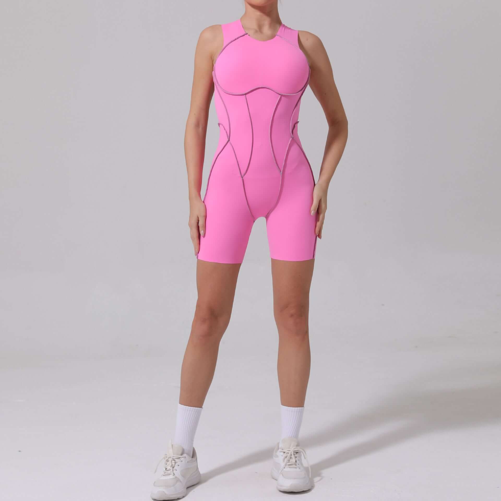 Woman wearing a pink seamless compression jumpsuit, front view, highlighting athletic design and sleek fit.