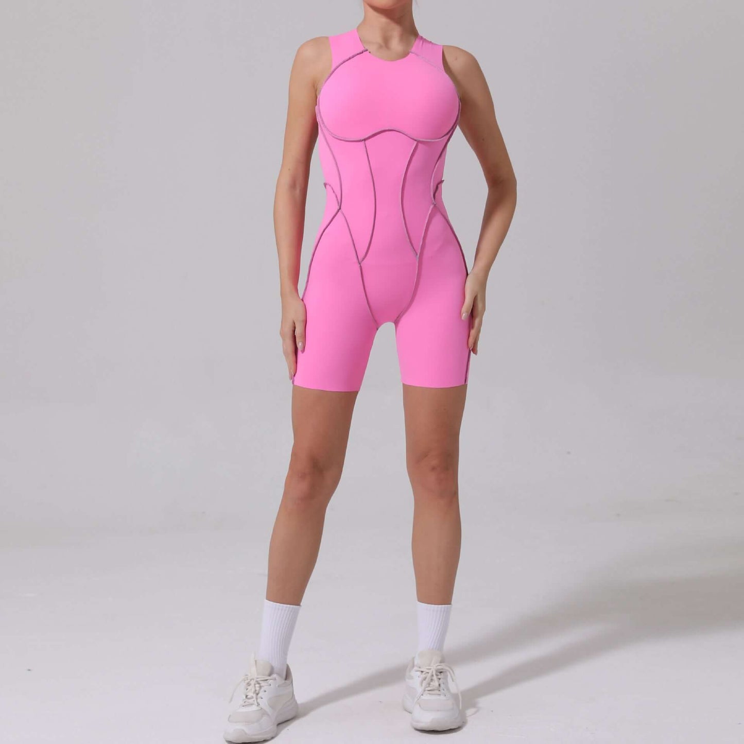 Bright pink seamless yoga jumpsuit made from organic cotton with a relaxed, breathable, and lightweight fit for flexibility.