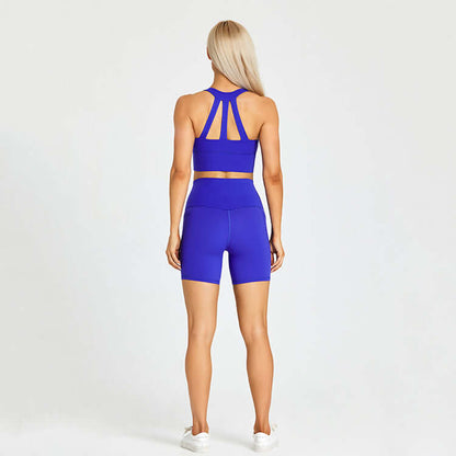 Woman in blue sportswear set, viewed from the back, against a plain background, highlighting fitness and outdoor sport style.