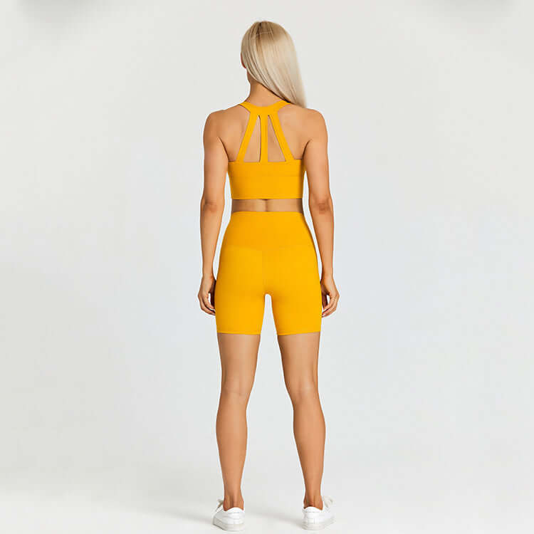 Woman in yellow sports outfit, back view, demonstrating activewear set with racerback top and high-waisted shorts suitable for outdoor sports.