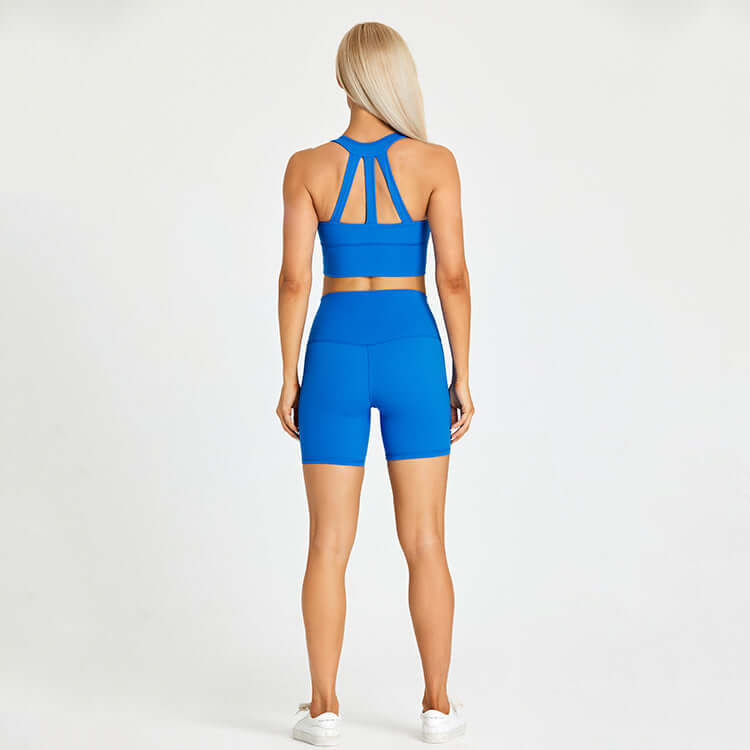 Back view of woman in blue athletic set for outdoor sports and fitness activities.