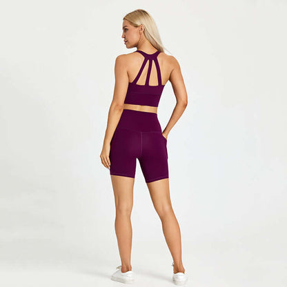 Woman in purple sports set facing away, wearing athletic shorts and top, ideal for outdoor activities.