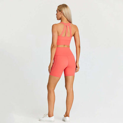 Woman wearing a coral sports bra and shorts set, ideal for outdoor sports and activities.
