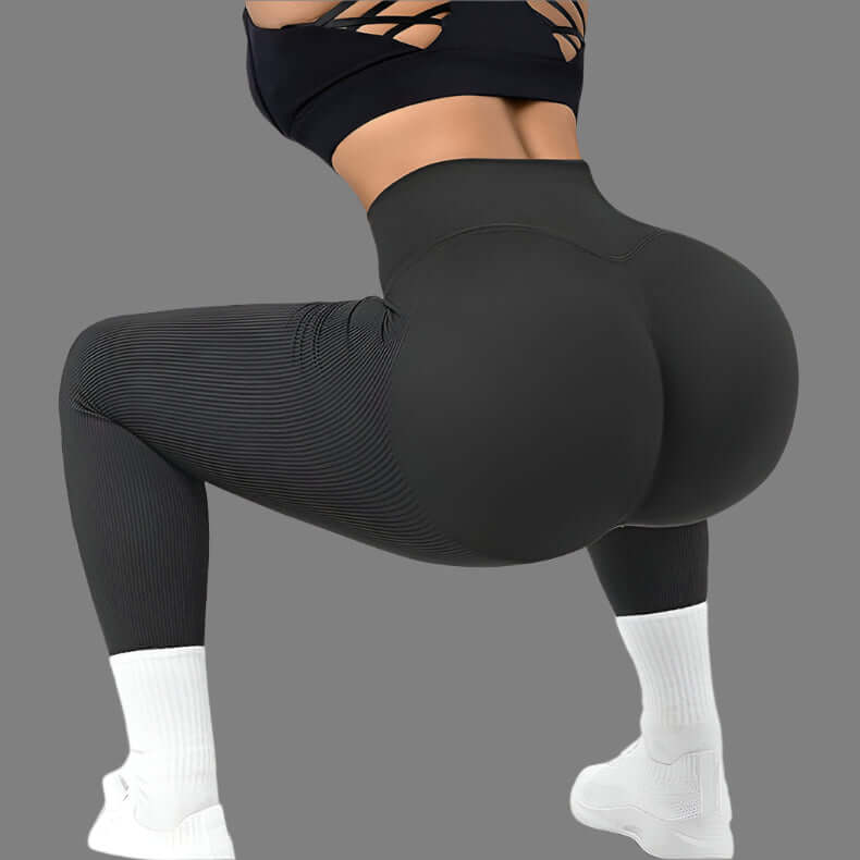 Seamless fitness leggings in black, showing squat position, emphasizing flexibility and shape-enhancing design. Available in multiple sizes.