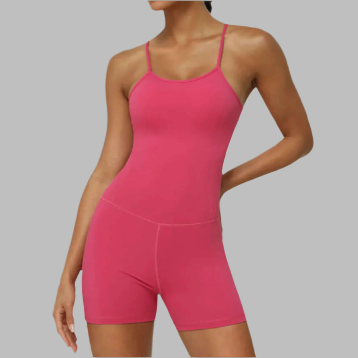 Strap sports jumpsuit in pink. Made from organic cotton. Features relaxed fit and breathable material.